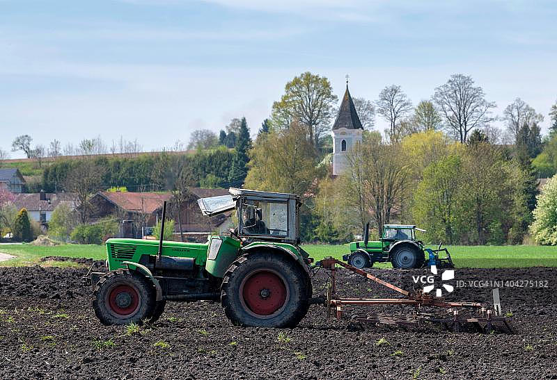 在德国巴伐利亚州维夫林附近田地里工作的拖拉机图片素材