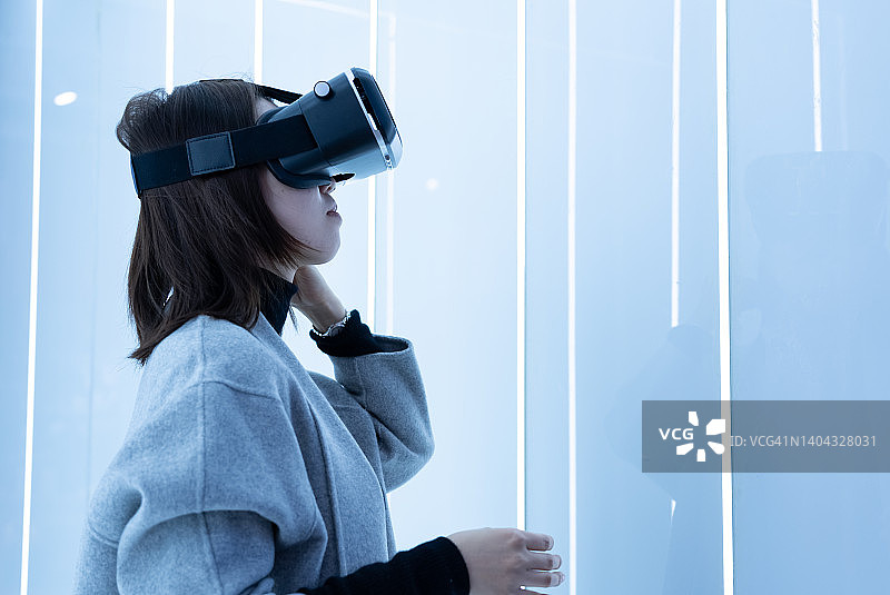 一位年轻女人在玩VR沉浸式游戏图片素材