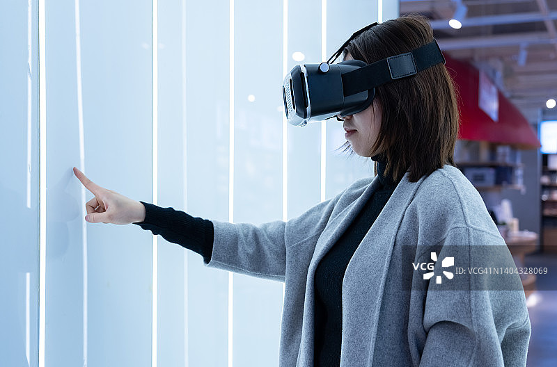 一位年轻女人在玩VR沉浸式游戏图片素材