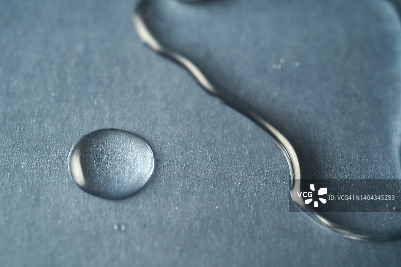 深蓝色背景上的化妆品液体凝胶或胶束水滴图片素材