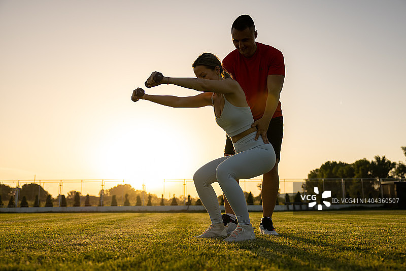 私人教练与女客户进行户外训练图片素材