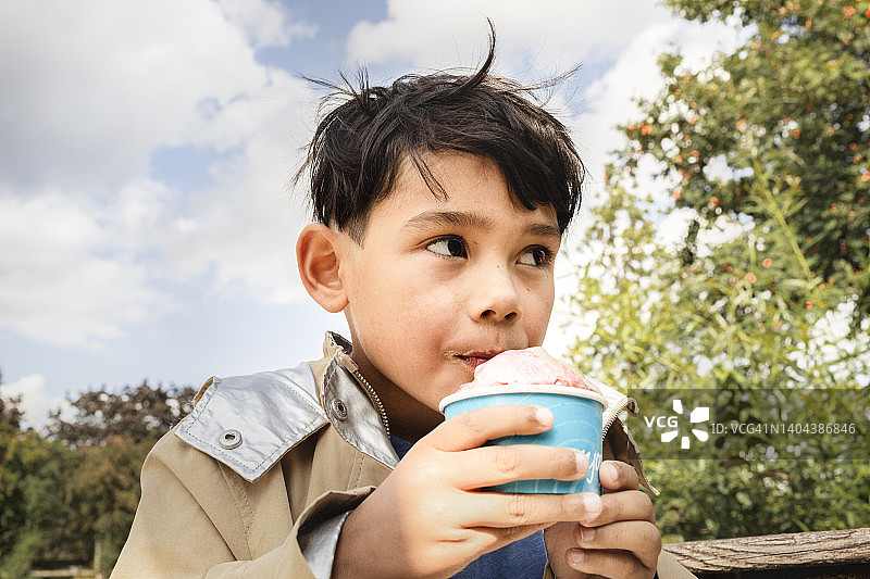 男孩吃杯装冰淇淋图片素材