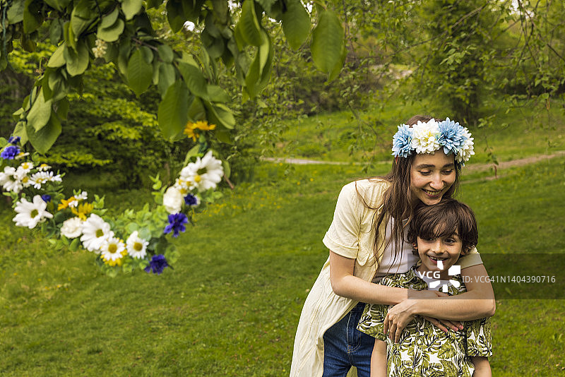 母亲在花园里拥抱儿子图片素材