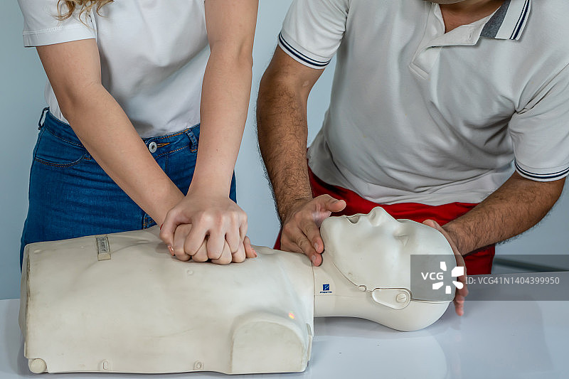急救员在CPR训练模型上进行胸部按压图片素材