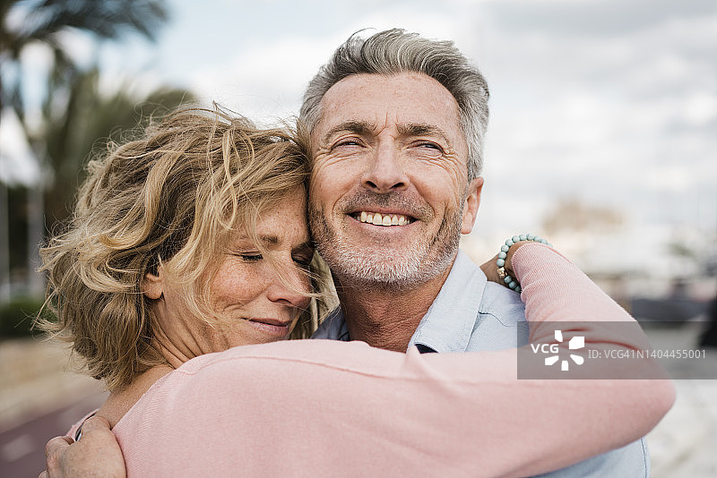快乐的中年夫妇在户外拥抱图片素材