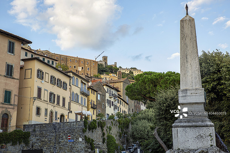 意大利阿雷佐省科尔托纳加里波第广场的纪念碑与城镇房屋背景图片素材
