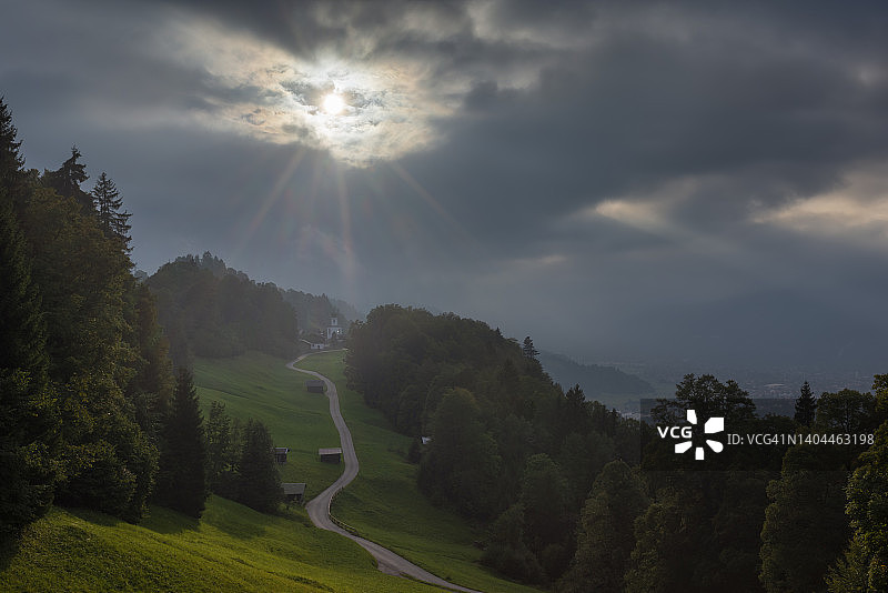 德国巴伐利亚州瓦姆贝格：通往韦特施泰因山脉偏远村庄的道路上空的阴天图片素材