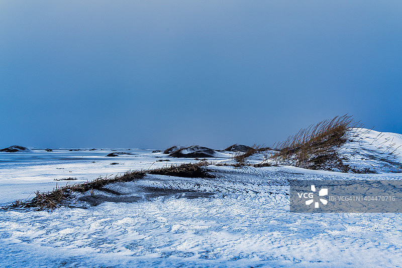 冰岛东南部斯托克斯内斯半岛的冬季雪景：泻湖与黑沙滩图片素材