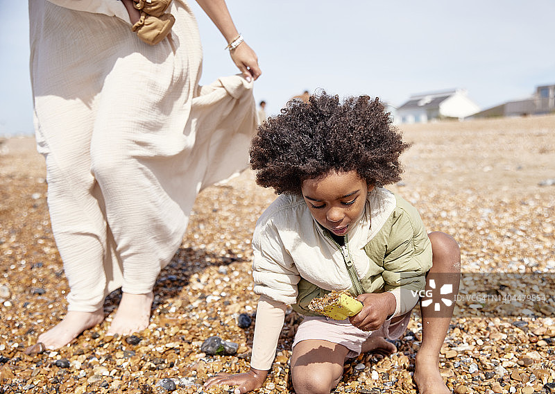 小男孩在海滩上挖沙图片素材