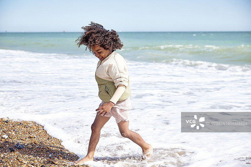 在阳光明媚的海滩上奔跑欢笑的男孩图片素材