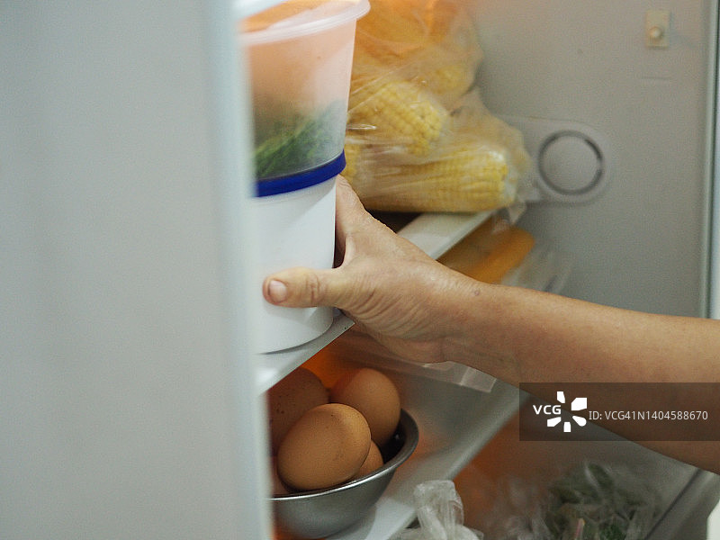 女子将手伸进冰箱图片素材