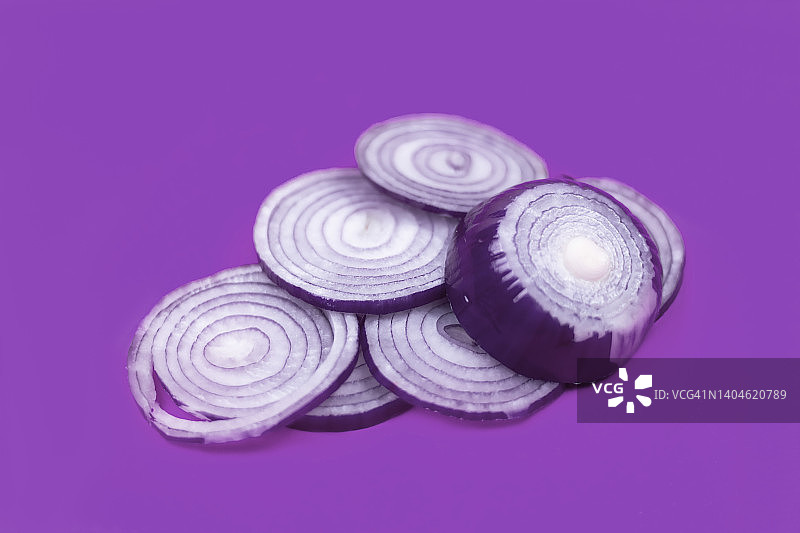 紫色背景上的红色洋葱切割图图片素材
