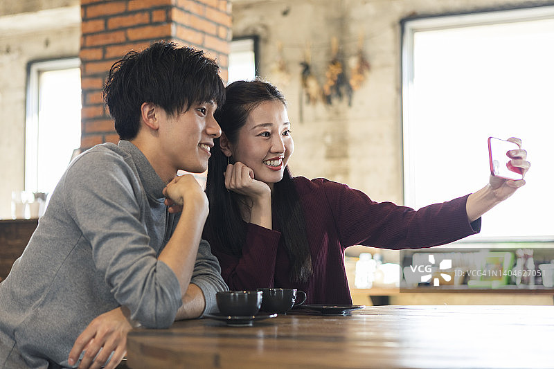 在咖啡馆拍照的男女图片素材