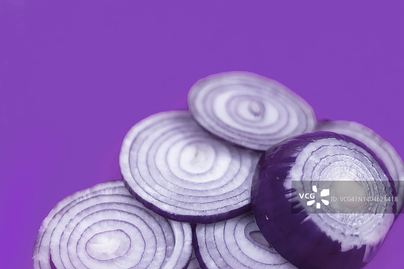 紫色背景上的红色洋葱切割图图片素材