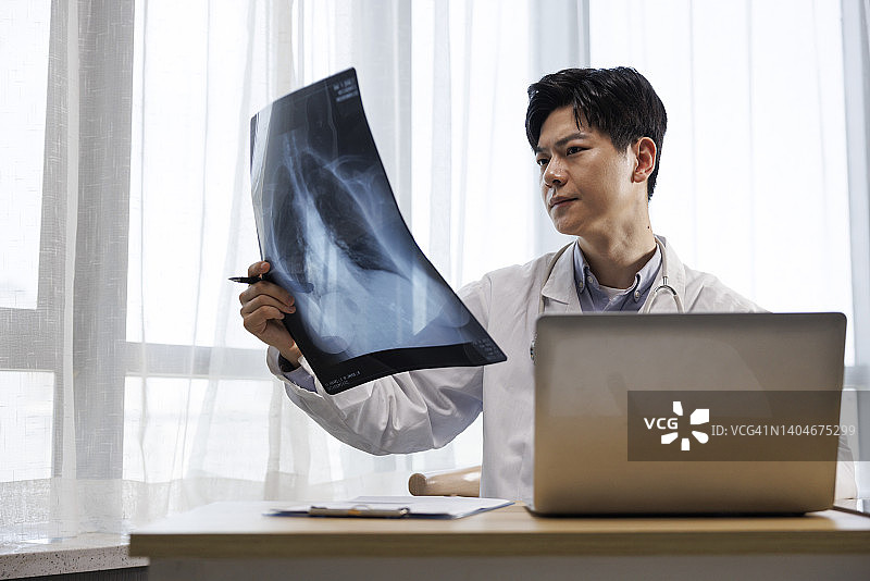 在办公室检查身体状况的年轻亚洲男医生图片素材