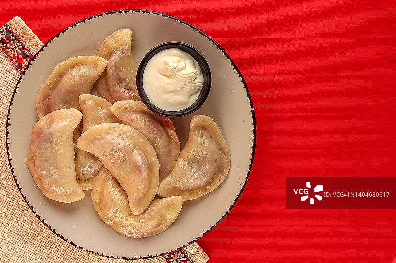 樱桃酸奶油饺子，鲜红色背景，乌克兰美食图片素材