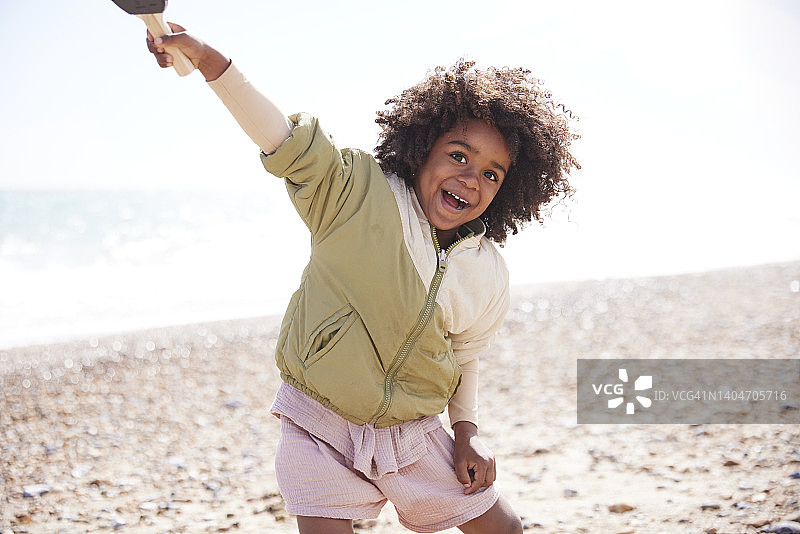 快乐的5岁男孩在海滩上和妈妈玩球图片素材