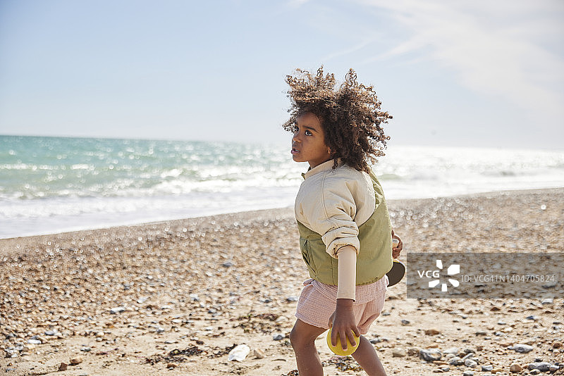 在阳光明媚的海滩上，决心赢得球棒和球的男孩图片素材