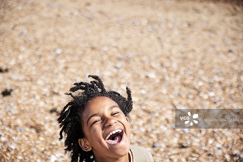 7岁男孩在海滩上开怀大笑图片素材