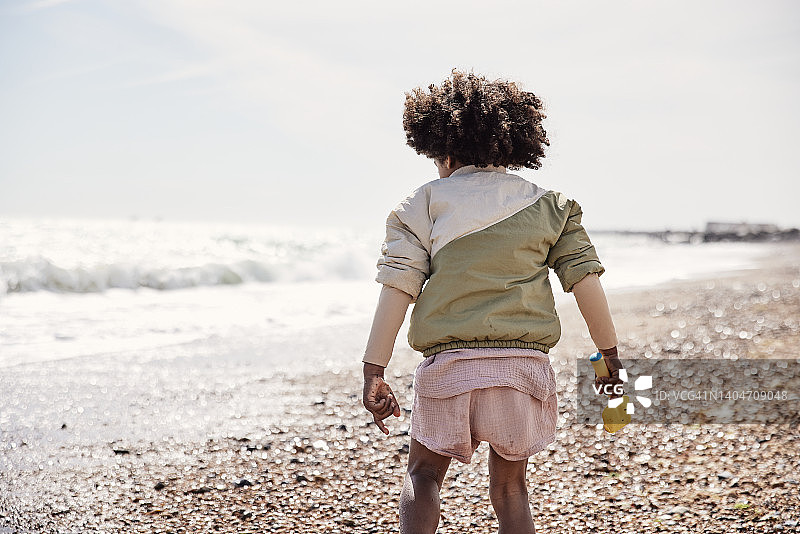 在海滩上玩耍的男孩，享受淡季家庭海滩之旅图片素材