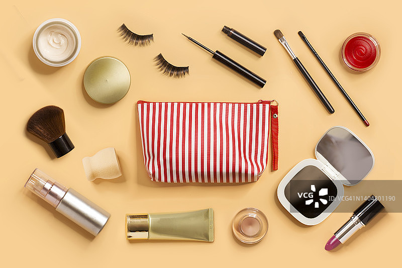 米色背景上的美容产品和化妆包静物俯视图图片素材