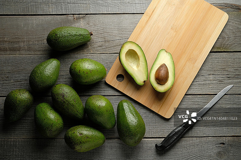 厨房里用刀在砧板上切半的牛油果图片素材