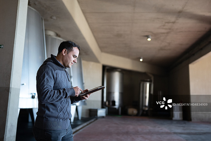 在酿酒厂使用平板电脑的中年男人图片素材