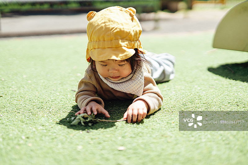 好奇的亚洲女婴在公园探索自然图片素材