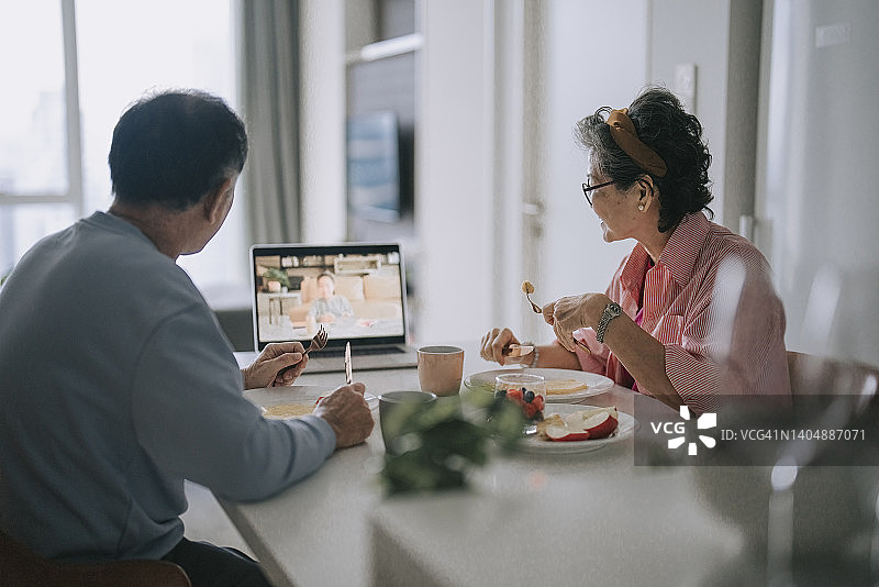 中国亚洲老年夫妇用笔记本电脑与孙女视频通话图片素材