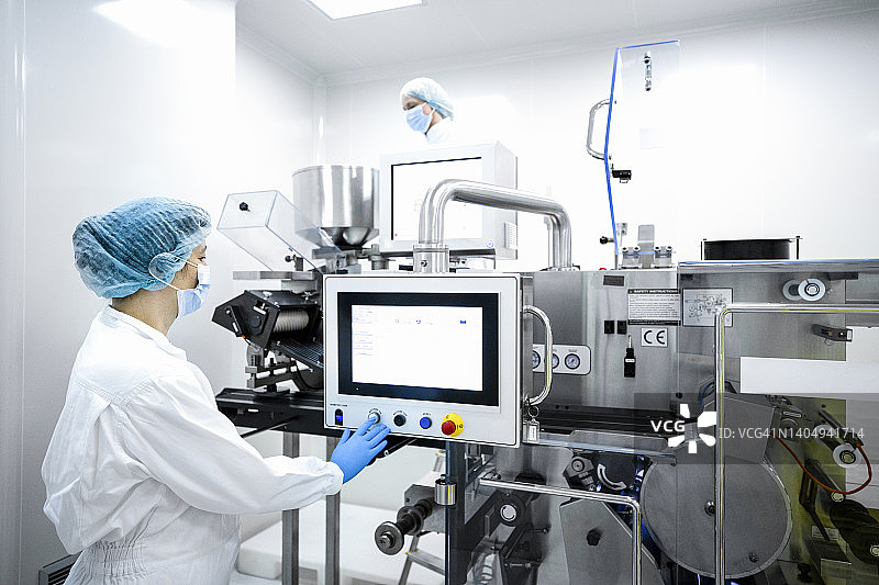 制药实验室中佩戴适当设备的女员工图片素材