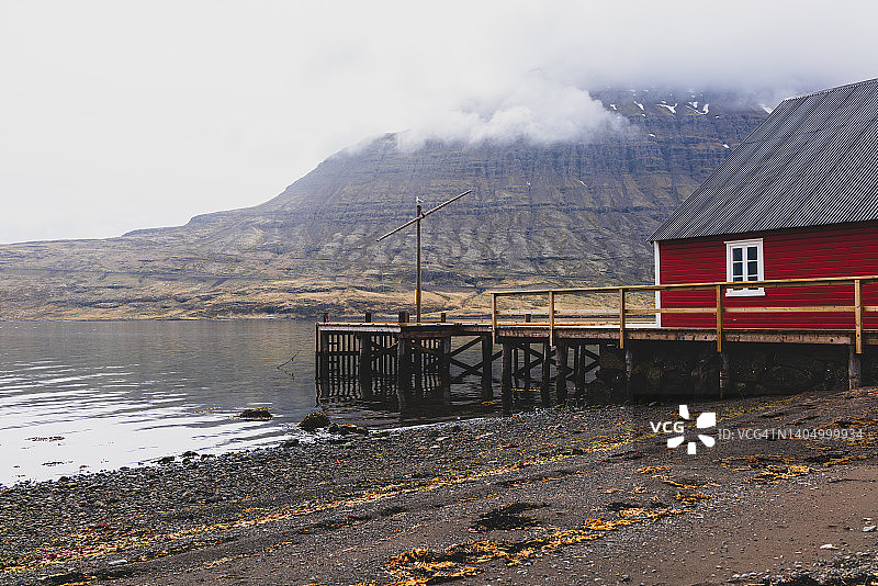 埃斯基峡湾：迷人的海边村庄，位于东部峡湾中部，红色且保存完好的房屋和渔棚排列在岸边，景色迷人图片素材