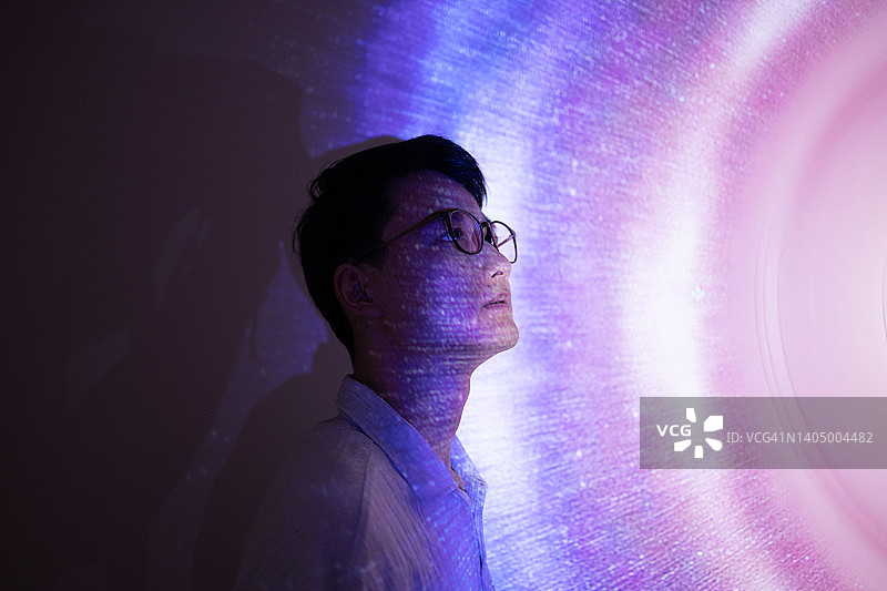 站在全息背景上的亚洲男人图片素材