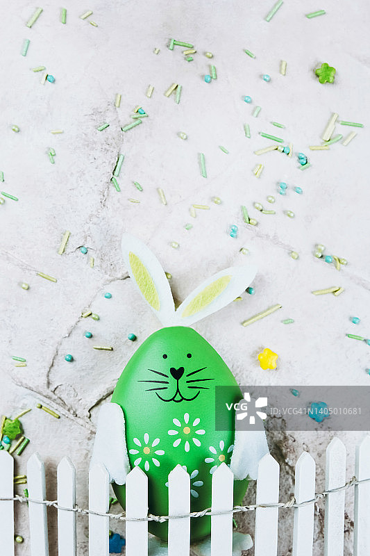 玩具木栅栏后的绿色复活节彩蛋图片素材