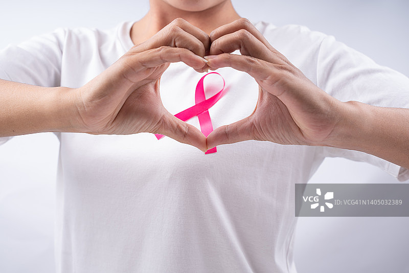 乳腺癌防治关爱：佩戴粉红丝带的女性图片素材