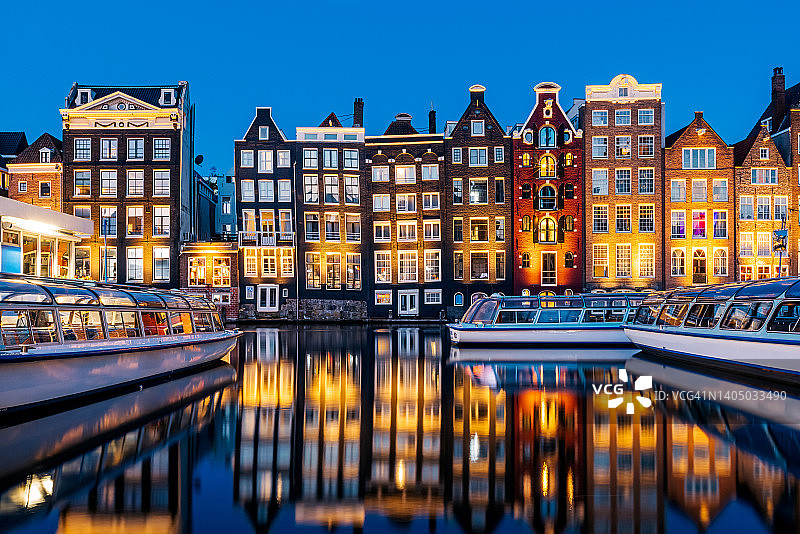 傍晚时分，荷兰阿姆斯特丹的传统荷兰运河房屋倒映在运河中图片素材