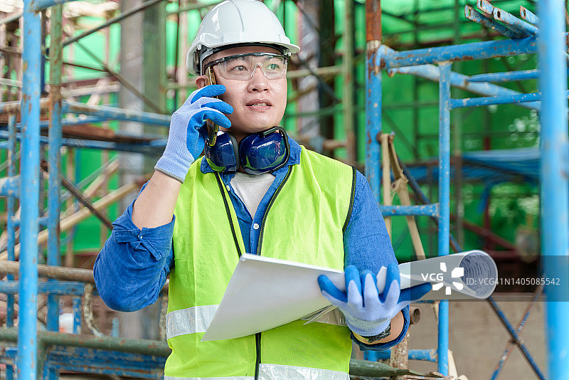 检查建筑项目进度的亚洲建筑工人图片素材
