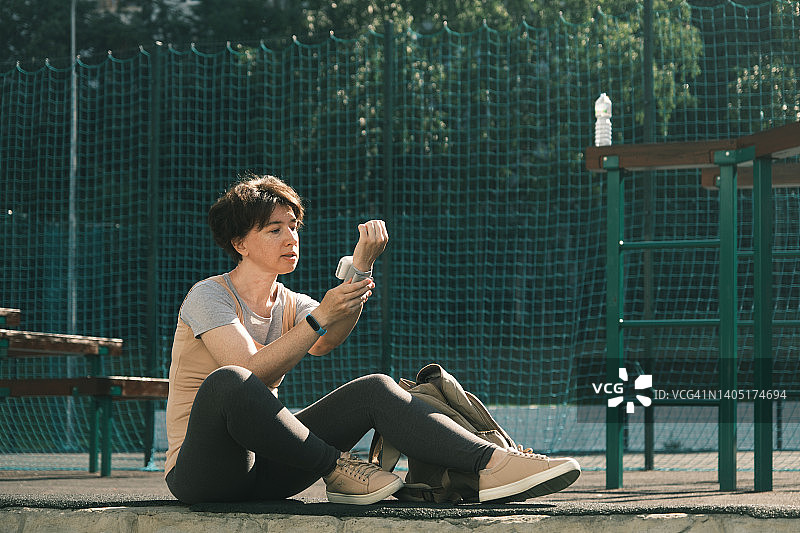 女人运动后正在测量血压图片素材