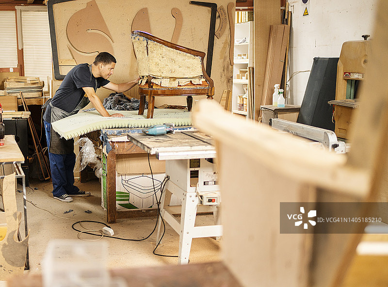 工人在工作台上重新装饰椅子图片素材