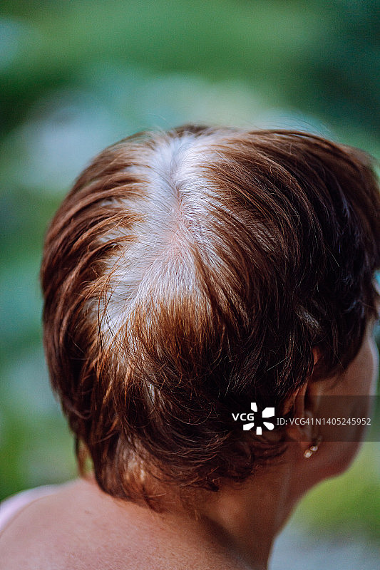 特写：女人棕红色短发，发根灰白图片素材