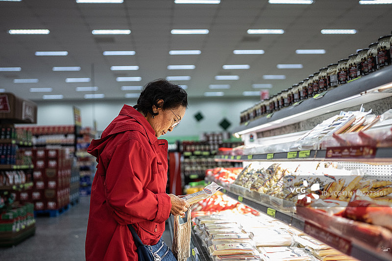 年长的女人在超市挑选意大利面图片素材