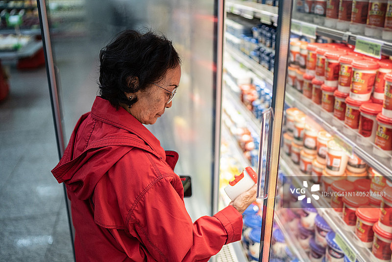 在超市购买乳制品的年长妇女图片素材