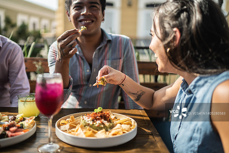 朋友们在餐厅里吃鳄梨酱图片素材