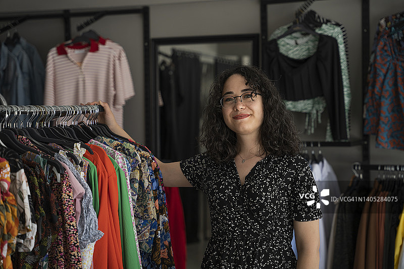 成功的小企业主年轻女性站在入口处看着镜头图片素材