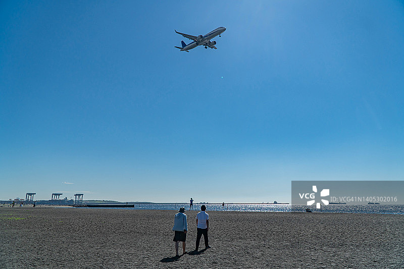 飞越东京海滩的飞机图片素材