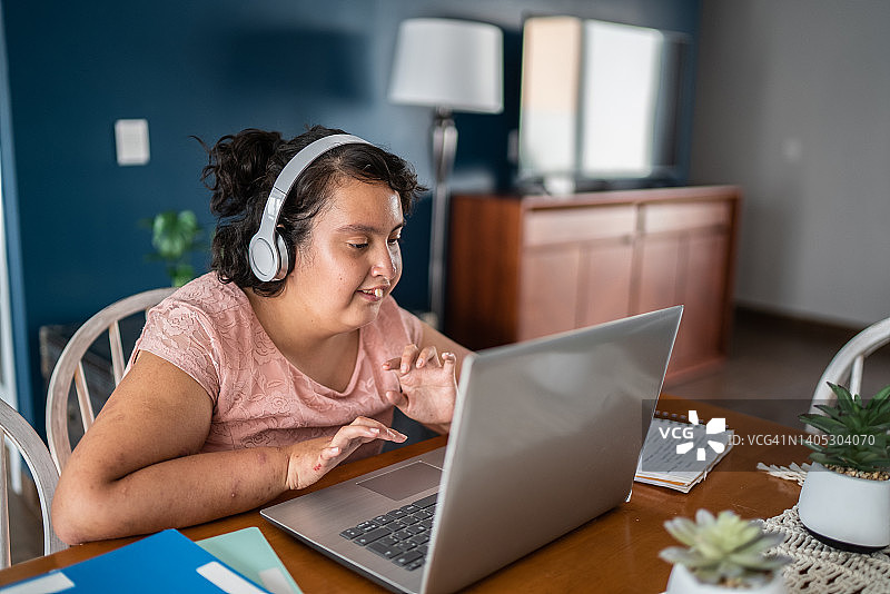 在家用笔记本电脑学习的智力障碍女孩图片素材