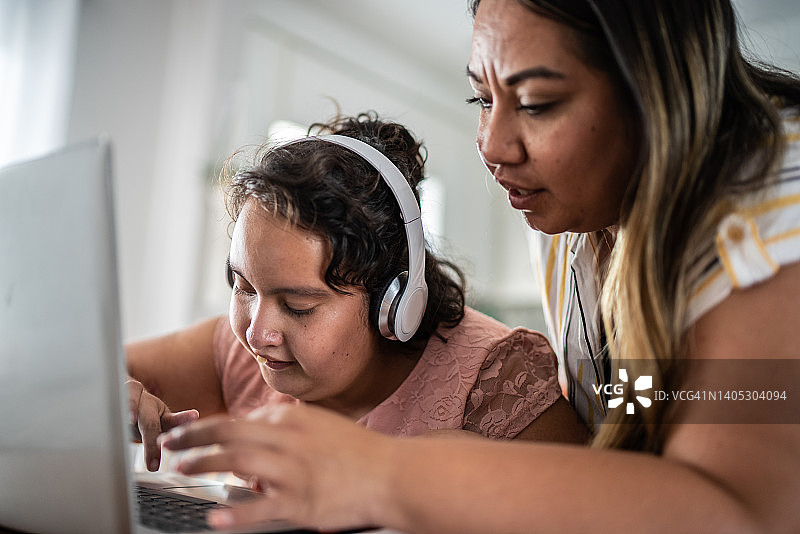 母亲帮助智力障碍女儿在家用电脑学习图片素材