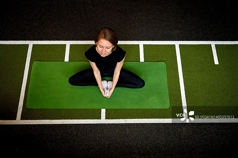 在垫子上做瑜伽的快乐女人图片素材