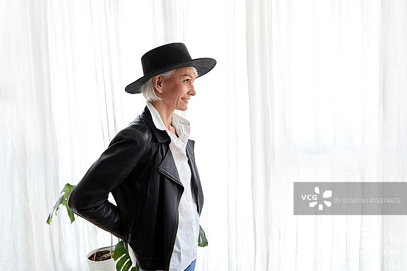 戴黑色帽子和皮夹克的年长女性图片素材