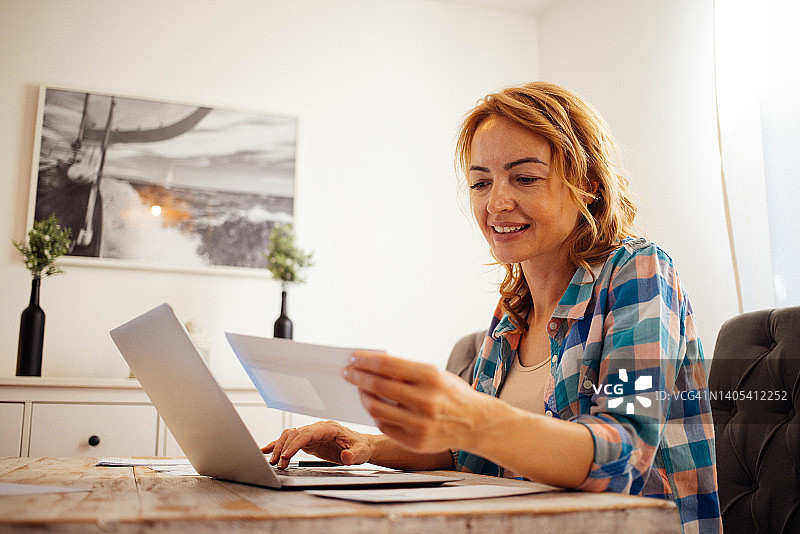 女人支付账单并在线工作图片素材