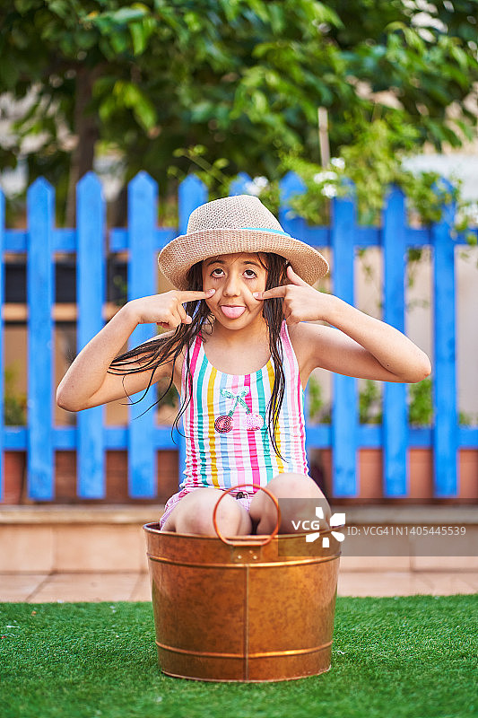 女孩在洗衣盆里做鬼脸图片素材